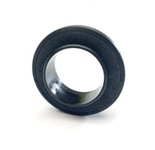 Charger l'image dans la galerie, Camshaft oil seal with black rubber edge and metallic inner surface, angled close-up