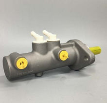Załaduj obraz do przeglądarki galerii, Brake master cylinder with yellow caps, two white fluid fittings, and mounting ports