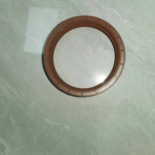 Carregar imagem no visualizador da galeria, Oil seal ring with brown outer edge and metal housing, overhead view