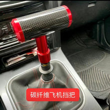 تحميل الصورة في عارض المعرض، Red carbon fiber gear shift knob with adapter installed in car interior.