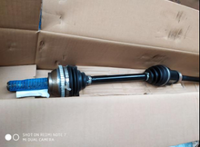 Load image into Gallery viewer, Front drive shaft with black boots and metal yoke end, angled view