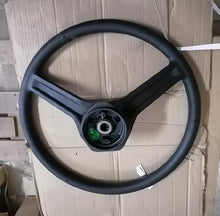 Carica l'immagine nel visualizzatore di Gallery, Black steering wheel with three spokes and circular hub center, visible mounting ring