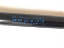 Carregar imagem no visualizador da galeria, Close-up of gas strut housing with printed part numbers and specifications