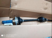 Charger l'image dans la galerie, Front drive shaft with black boots and metal yoke end, angled view