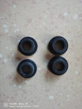 Carregar imagem no visualizador da galeria, Four black rubber gasket rings with inner openings, grouped on light surface