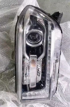 Load image into Gallery viewer, Close-up chrome and dark housing vehicle headlight with circular projector lens
