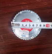 Load image into Gallery viewer, Fuel tank cap underside with serrated metal edge and size ruler across face
